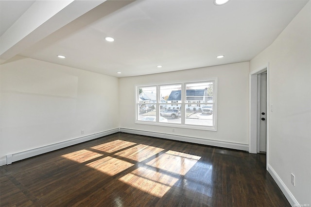 spare room featuring dark hardwood / wood-style floors and a baseboard radiator