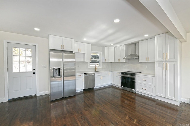 kitchen featuring sink, wall chimney exhaust hood, stainless steel appliances, dark hardwood / wood-style flooring, and white cabinets