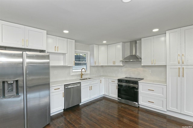 kitchen featuring stainless steel appliances, sink, wall chimney range hood, white cabinets, and dark hardwood / wood-style floors