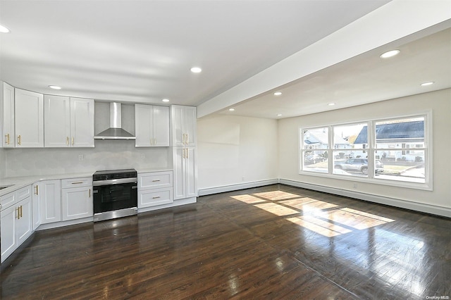 kitchen with white cabinets, wall chimney range hood, dark hardwood / wood-style floors, stainless steel range, and tasteful backsplash