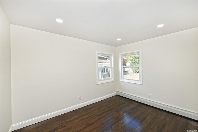 empty room with dark wood-type flooring and a baseboard radiator