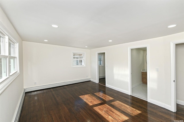 unfurnished bedroom with dark wood-type flooring, connected bathroom, and a baseboard radiator