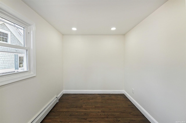 unfurnished room featuring a wealth of natural light, a baseboard radiator, and dark hardwood / wood-style floors