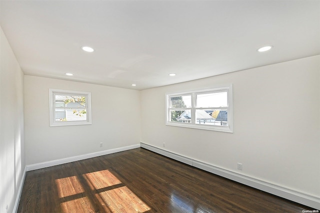 unfurnished room with baseboard heating and dark wood-type flooring