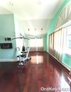 workout area featuring hardwood / wood-style flooring and lofted ceiling