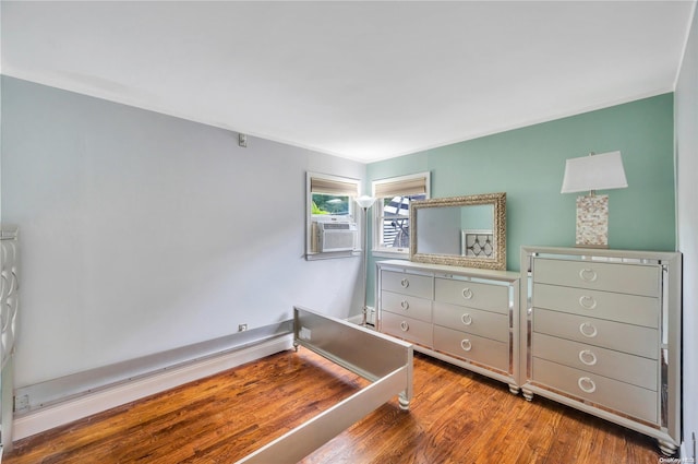 bedroom featuring hardwood / wood-style flooring, cooling unit, and a baseboard heating unit