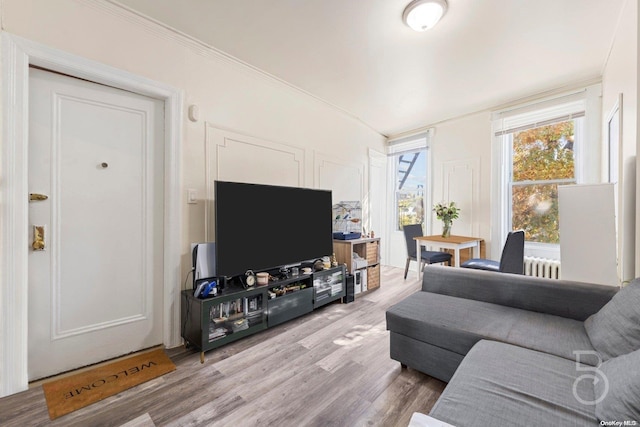 living room featuring light hardwood / wood-style flooring and ornamental molding