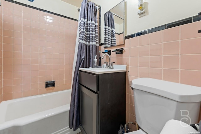 bathroom with vanity, shower / bathtub combination with curtain, and tile walls