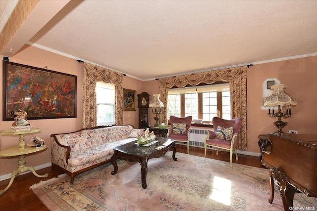 living room with hardwood / wood-style flooring, plenty of natural light, beam ceiling, and ornamental molding