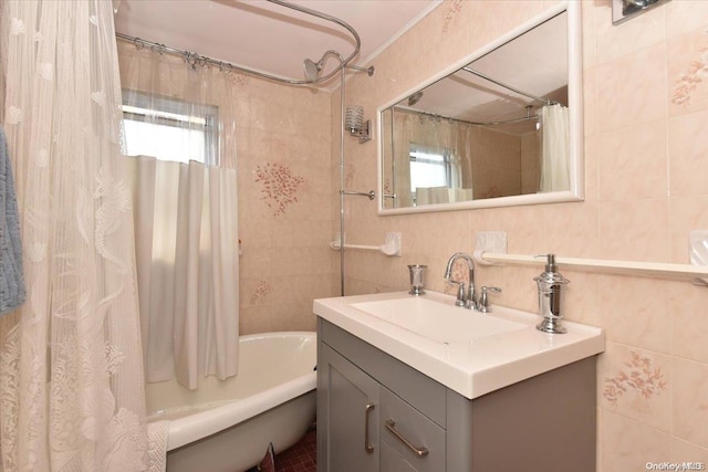 bathroom with vanity, tile walls, a wealth of natural light, and shower / tub combo with curtain