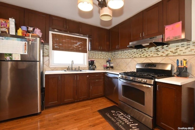 kitchen featuring tasteful backsplash, sink, stainless steel appliances, and light wood-type flooring