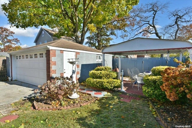 view of side of home featuring a yard, an outdoor structure, and a garage