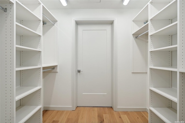 spacious closet with light hardwood / wood-style flooring