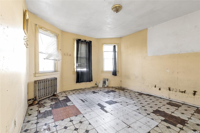 spare room featuring plenty of natural light and radiator