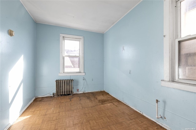 empty room featuring radiator heating unit and light parquet floors