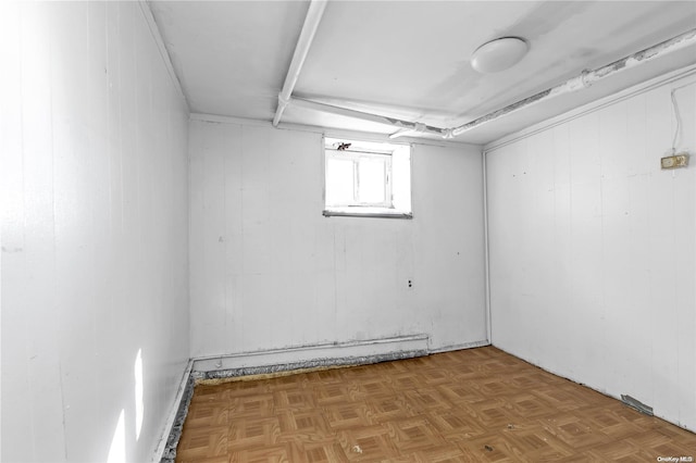 basement featuring wood walls and parquet floors