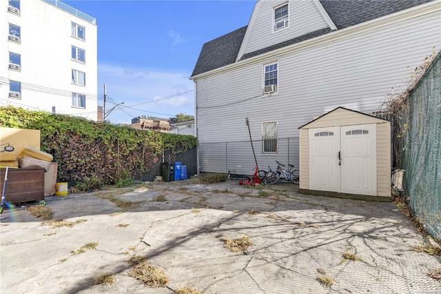 back of property with a shed and a patio area