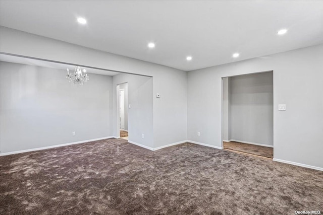 spare room with carpet floors and a chandelier