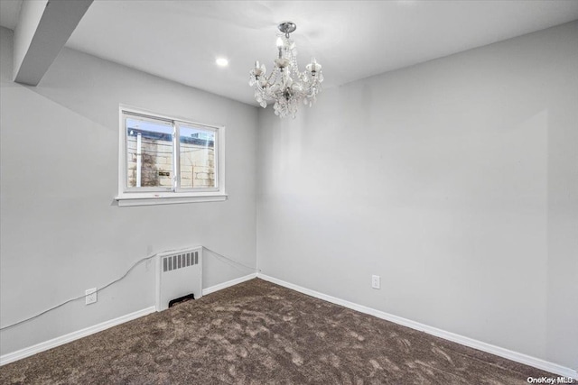 empty room featuring carpet, radiator, and a notable chandelier