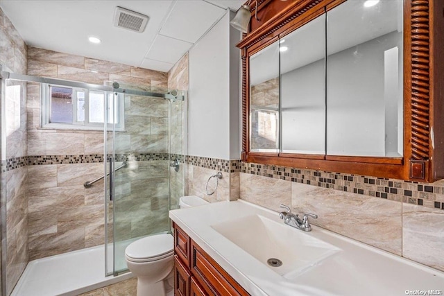 bathroom with tasteful backsplash, an enclosed shower, vanity, tile walls, and toilet