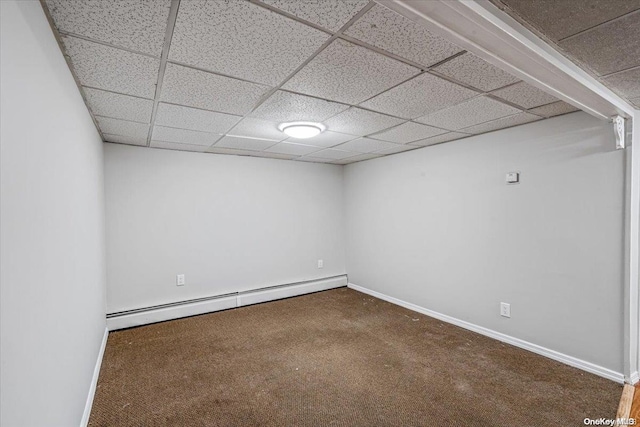 unfurnished room featuring dark colored carpet, a paneled ceiling, and baseboard heating