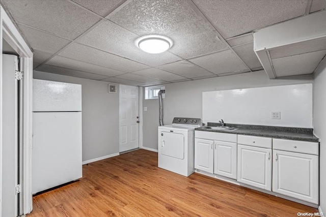 kitchen featuring white cabinetry, sink, washer / clothes dryer, white fridge, and light hardwood / wood-style floors