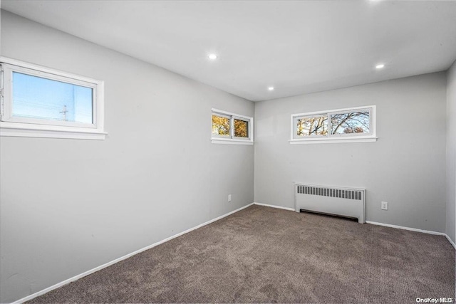 empty room with radiator heating unit and carpet floors