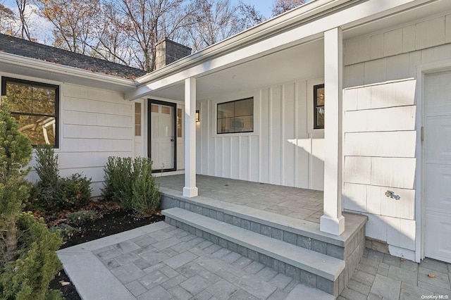 471A Woodbury Rd Unit A, Cold Spring Harbor, NY 11724 - view of exterior entry featuring covered porch, a chimney, and board and batten siding