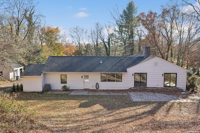 back of property featuring a lawn and central AC