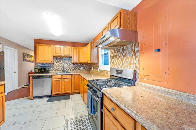 kitchen featuring sink, decorative backsplash, light tile patterned floors, appliances with stainless steel finishes, and range hood