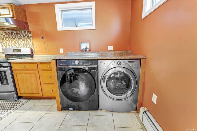 washroom featuring separate washer and dryer, light tile patterned flooring, and a baseboard radiator