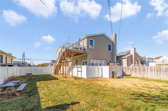 back of property featuring a yard and a wooden deck