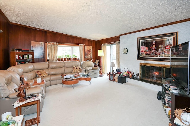 living room with a large fireplace, wood walls, lofted ceiling, a textured ceiling, and ornamental molding