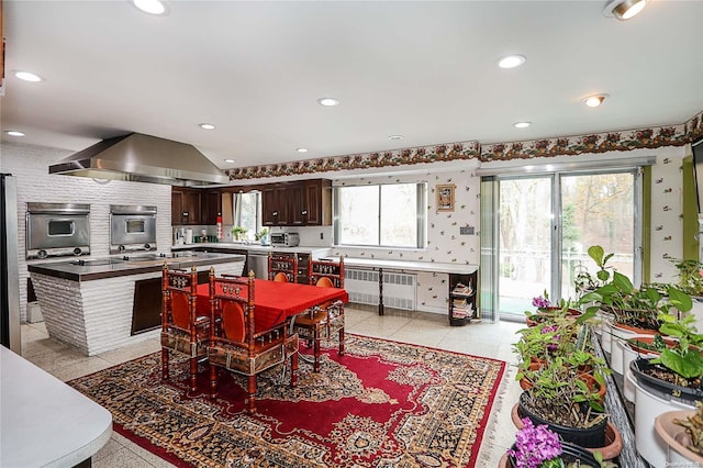 tiled dining room with radiator and a healthy amount of sunlight