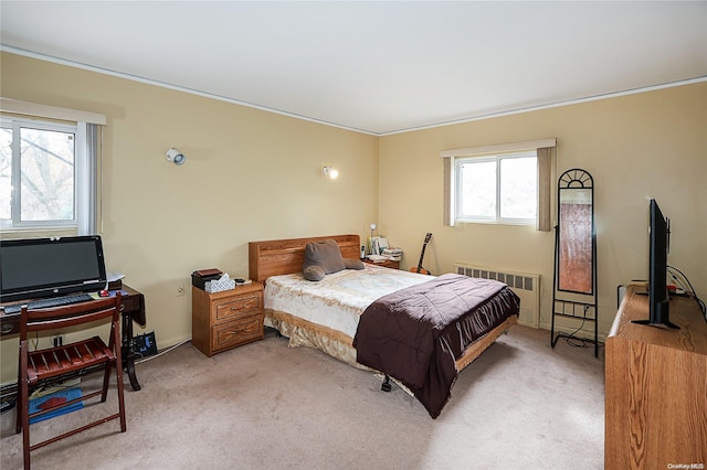 carpeted bedroom featuring radiator and crown molding