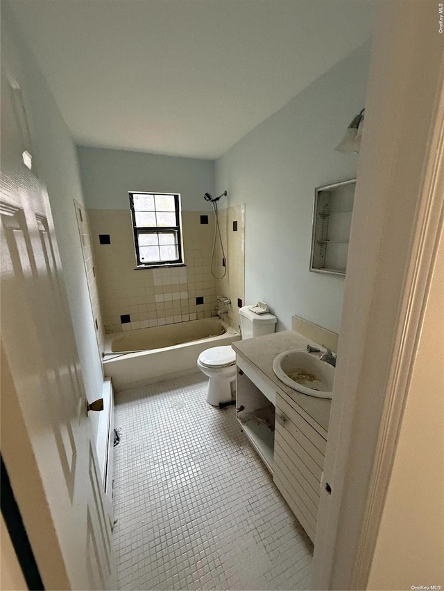 full bathroom with tile patterned flooring, vanity, tiled shower / bath combo, and toilet