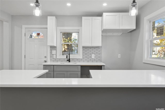 kitchen with backsplash, gray cabinetry, sink, pendant lighting, and white cabinets