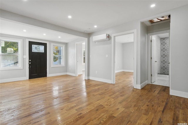 entryway with hardwood / wood-style floors and a wall mounted air conditioner