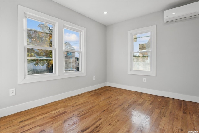 empty room featuring an AC wall unit and hardwood / wood-style flooring