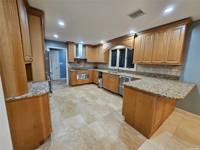 kitchen with wall chimney range hood, visible vents, a sink, a peninsula, and a warming drawer