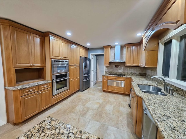 kitchen with light stone countertops, a sink, a warming drawer, stainless steel appliances, and wall chimney exhaust hood