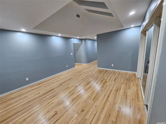 finished below grade area featuring baseboards, recessed lighting, and wood finished floors
