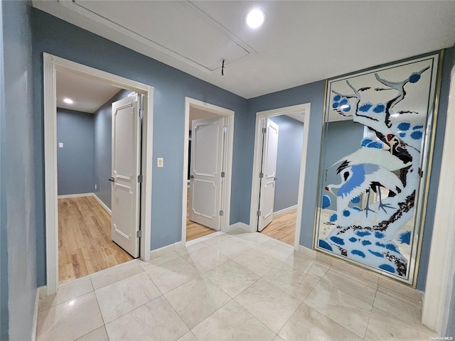hall featuring baseboards and attic access
