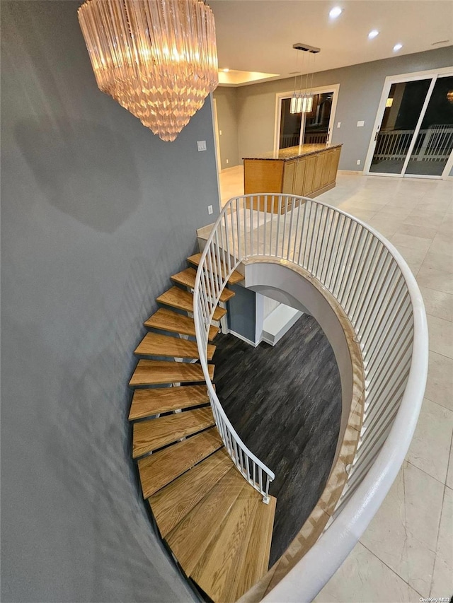 stairs with an inviting chandelier, recessed lighting, and baseboards