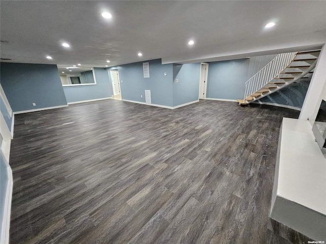 finished below grade area featuring stairs, recessed lighting, baseboards, and dark wood finished floors