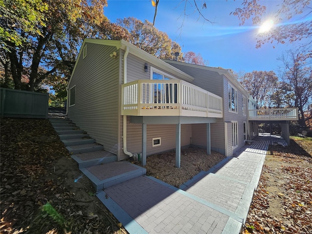 view of property exterior featuring a wooden deck and stairs