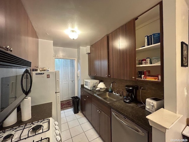 kitchen featuring sink, backsplash, white appliances, dark brown cabinets, and light tile patterned floors