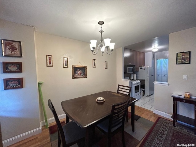 dining area with a chandelier and light hardwood / wood-style floors