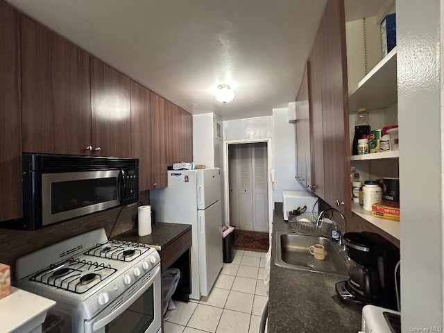 kitchen with wood walls, sink, light tile patterned floors, and white appliances