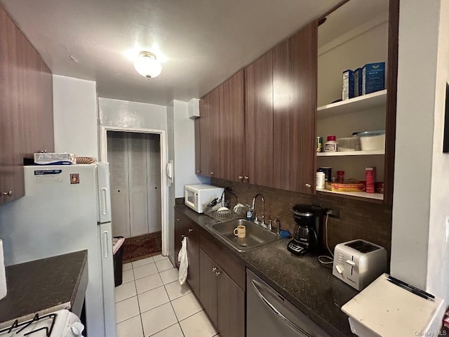 kitchen featuring decorative backsplash, dark brown cabinets, white appliances, sink, and light tile patterned flooring